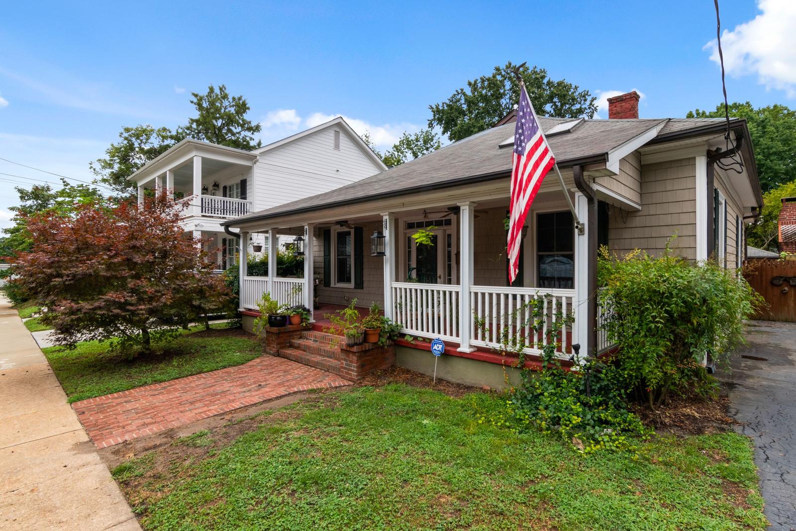 A modest bungalow with a front porch and lawn