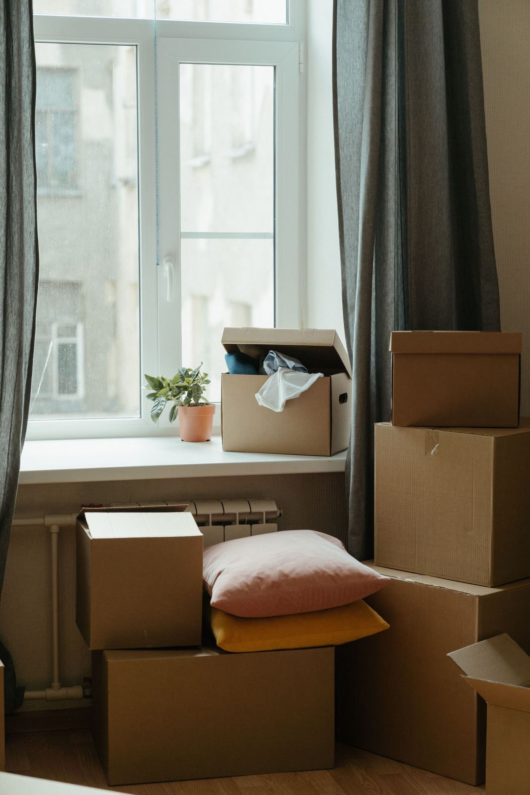 Stacked moving boxes beside an apartment window